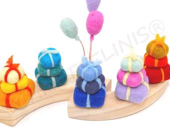 May include: A wooden stacking toy with felt pieces shaped like presents and balloons. The presents are stacked in different colors, including blue, green, yellow, pink, and purple. The balloons are light blue and pink.