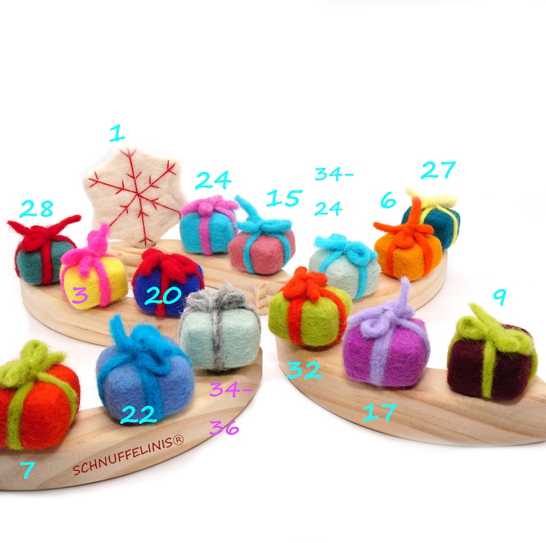 May include: A wooden advent calendar with felt ornaments shaped like wrapped gifts. The gifts are in various colors, including red, green, blue, yellow, purple, and brown. The numbers 1 through 36 are written on the ornaments.