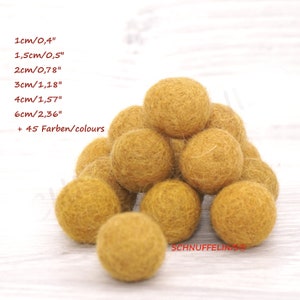 May include: A pile of mustard yellow felt balls. Text on the left lists sizes: 1cm/0.4", 1.5cm/0.5", 2cm/0.78", 3cm/1.18", 4cm/1.57", 6cm/2.36" + 45 Farben/colours. The text SCHNUFFELINIS is visible in the bottom right corner.