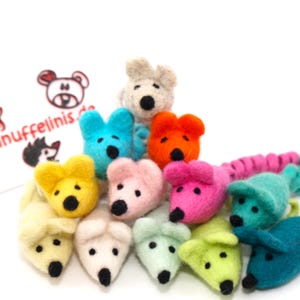 Könnte beinhalten: Eine Sammlung bunter Filzmaus-Spielzeuge in verschiedenen Farbtönen, darunter Blau, Rosa, Gelb und Grün. Jede Maus hat eine schwarze Nase und kleine Ohren. Einige Mäuse sind durch einen gewendelten Schwanz verbunden. Der Hintergrund enthält ein Logo mit Text.