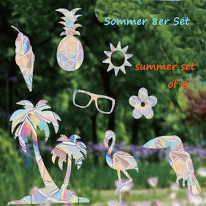 Op de afbeelding: Een zomerse set van 8 decoratieve uitsparingen, waaronder een ananas, een zonnebril en een flamingo. De uitsparingen hebben een kleurrijk glas-in-lood effect. Tekst op de afbeelding luidt "Sommer 8er Set" en "summer set of 8".