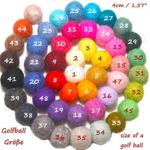 Peut inclure: Une collection de 48 boules en feutre colorées, chacune d'environ 4 cm de diamètre, disposées en cercle. Les boules sont numérotées et étiquetées avec le texte "Golfball Größe" et "size of a golf ball."