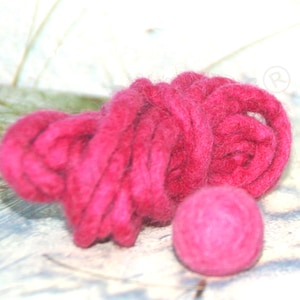 May include: A close-up of a vibrant fuchsia-colored yarn ball and a skein of thick, chunky yarn. The yarn has a soft, textured appearance, suggesting it is made of wool or a similar fiber. The items are likely for knitting or other crafts.