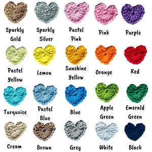 May include: Twenty-five crocheted heart shapes in a variety of colours, such as gold, silver, pink, purple, yellow, orange, red, blue, green, cream, brown, grey, white, and black. Each heart has a colour name beneath it.