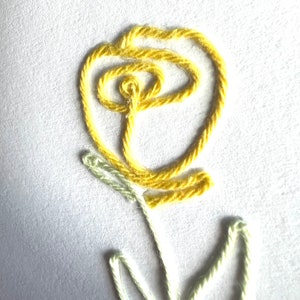 Peut inclure: Une fleur brod&eacute;e jaune avec une tige et des feuilles vertes. La fleur est r&eacute;alis&eacute;e avec un seul brin de fil et est brod&eacute;e en forme circulaire.