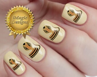 May include: Close-up of fingernails with gold and black snake nail art decals. The decals feature a detailed snake design with a gold body and black accents.