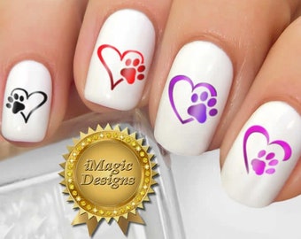 Op de afbeelding: Nageldecoraties met pootjes in hartjes. De stickers zijn te zien op een set gemanicuurde nagels. De stickers zijn verkrijgbaar in drie kleurcombinaties: rood en roze, paars en roze, en zwart.