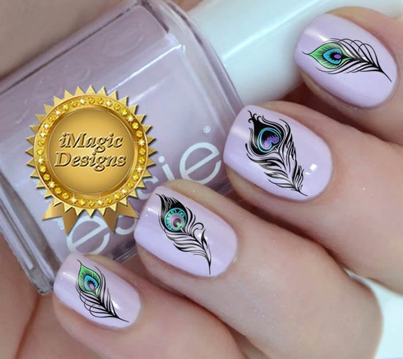 May include: Four fingernails with nail art featuring peacock feathers. The feathers are black with blue and green accents. The nail polish is a light purple color.