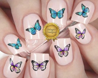 Op de afbeelding: Nageldecoraties met kleurrijke vlinderontwerpen. De stickers worden op de vingernagels aangebracht en bevatten vlinders in tinten blauw, paars en geel.