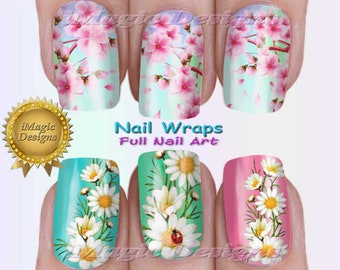 Op de afbeelding: Volle nagelwraps met twee ontwerpen: roze en witte kersenbloesems op een blauwe achtergrond en witte madeliefjes op een groene en roze achtergrond. De tekst "Nail Wraps Full Nail Art" is op de afbeelding gedrukt.