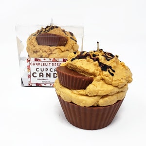 May include: A chocolate cupcake candle with a peanut butter cup filling and chocolate drizzle. The candle is in a clear plastic container with a label that reads "Candlelit Dessert Cupcake Candle" and "Fragrance: CandlelitDessert".
