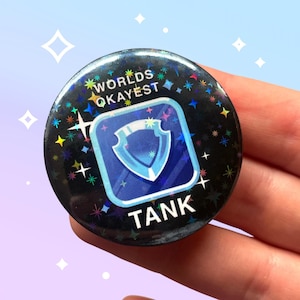 El mejor tanque del mundo, insignia de 44 mm con pin brillante inspirado en FFXIV, meme de juego MMO RPG, holográfico, estética de fantasía.