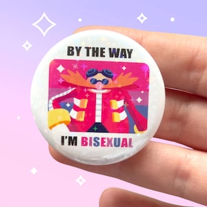 Peut inclure: Un badge rond et blanc avec le texte "BY THE WAY I'M BISEXUAL" en noir et rose. Il présente un personnage de dessin animé avec une grande moustache orange, portant des lunettes et une veste rouge. Le fond a des accents roses et violets.