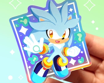 May include: A holographic sticker featuring Silver the Hedgehog from the Sonic the Hedgehog video game series. Silver has white fur, blue eyes, and a yellow and orange headband. He is posed with his arms outstretched, as if he is about to run. The sticker is set against a background of blue, purple, and green swirls.