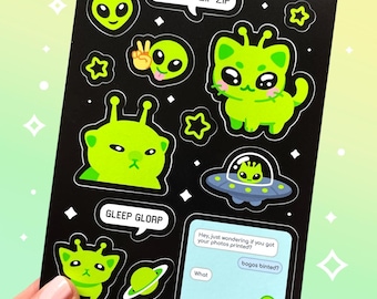 Puede incluir: Hoja de pegatinas negra con ilustraciones de extraterrestres verdes, incluyendo un alienígena con forma de gato, un OVNI y bocadillos de diálogo con texto. El texto incluye frases como "Zim Zorp Zip Zip" y "Gleep Glorp."