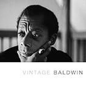 May include: Black and white photograph of James Baldwin, with the text "VINTAGE BALDWIN" in a minimalist font. Baldwin is shown with his hand on his chin, looking thoughtful. The image is a portrait, likely for a book cover or print.