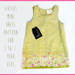 Puede incluir: Un vestido mini verde sin mangas con estampado floral y una etiqueta blanca que dice "The Collective". El vestido tiene un dobladillo festoneado y es para edades de 3 a 7 años. El texto "Sixties Mini Dress Pattern for 3 to 7 Year Olds" está escrito en el lado izquierdo de la imagen.