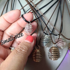 May include: A variety of crystal cage pendants on brown and black cords. The pendants are made of silver wire and contain different colored crystals. The text "small size" is written on the image.