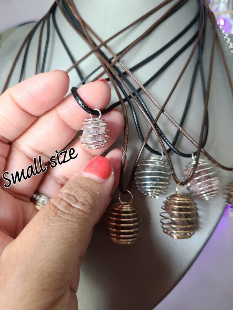 May include: A variety of crystal cage pendants on brown and black cords. The pendants are made of silver wire and contain different colored crystals. The text "small size" is written on the image.