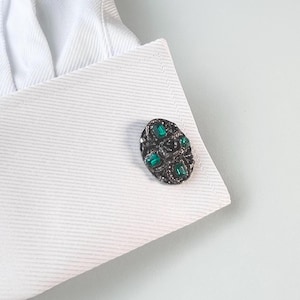 Vintage cufflinks with green rhinestones in a 70s era Medieval inspired setting