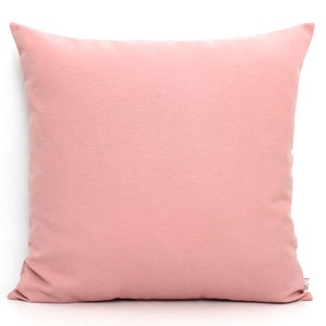 May include: A soft, blush pink throw pillow with a smooth, solid color. The pillow is made of a soft, comfortable fabric and is perfect for adding a touch of color to any room.