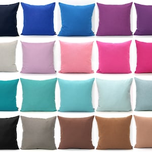 May include: A set of 18 decorative throw pillows in various solid colours, including black, blue, pink, teal, and brown. The pillows are arranged in three rows of six, with each row featuring a different colour.