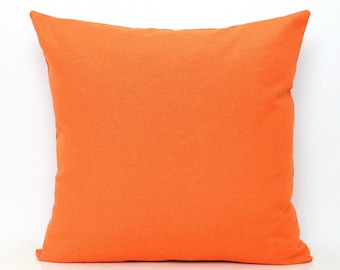 Op de afbeelding: Een vierkante kussenhoes in een effen, levendige oranje kleur. De stof heeft een gladde, matte textuur met strakke, rechte randen en puntige hoeken, wat zorgt voor een eenvoudige, uniforme uitstraling zonder patronen of versieringen.