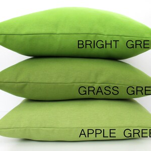 May include: Three green cushions stacked. The top cushion is bright green, the middle is grass green, and the bottom is apple green. Text on the image labels each cushion's colour.
