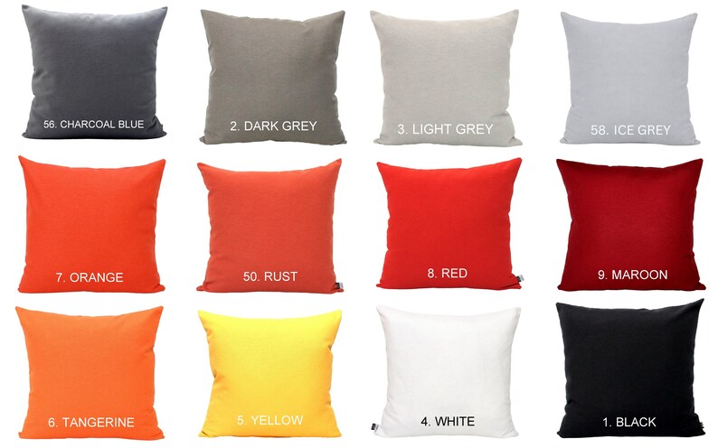 May include: A selection of square cushions in a range of solid colours: charcoal blue, dark grey, light grey, ice grey, orange, rust, red, maroon, tangerine, yellow, white, and black. Each cushion is labelled with a number.