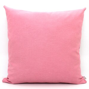 Puede incluir: Una almohada suave y rosa con una textura lisa y uniforme. La almohada est&aacute; hecha de una tela suave y c&oacute;moda.