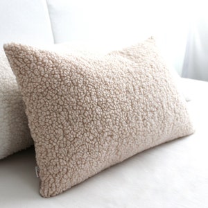 May include: A white ceramic mug with a black handle and the text "But first, coffee" in a black, handwritten-style font. The mug is on a white surface.