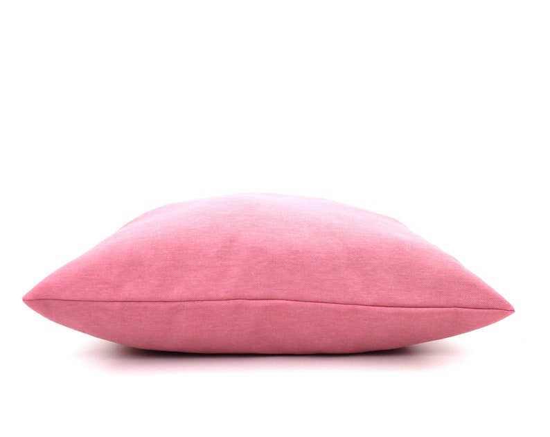 Puede incluir: Una almohada suave de color rosa con un degradado de rosa claro a rosa oscuro.