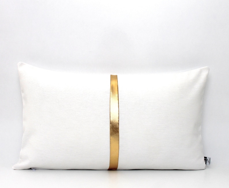 May include: White rectangular pillow with a gold stripe down the center.
