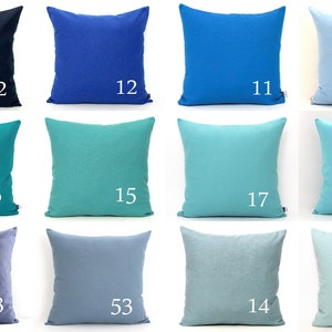 K&ouml;nnte beinhalten: Eine Sammlung von zw&ouml;lf quadratischen Zierkissen in verschiedenen Blau- und T&uuml;rkist&ouml;nen. Jedes Kissen hat eine einfarbige Farbe und eine wei&szlig;e Nummer in der Ecke. Die Farben reichen von Marineblau bis Hellblau und Aqua.