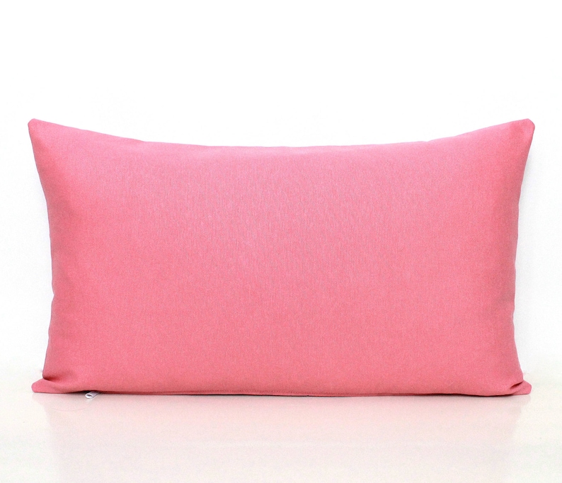 Puede incluir: Una almohada rectangular de color rosa s&oacute;lido con una textura lisa y uniforme.