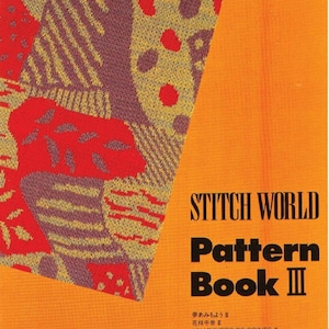 Könnte beinhalten: Ein leuchtend orangefarbener Buchumschlag mit dem Titel "Stitch World Pattern Book II" in schwarzer Schrift. Der Umschlag zeigt ein farbenfrohes geometrisches Muster in Rot, Gelb und Braun.
