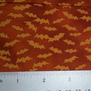 Puede incluir: Tela naranja con un patrón repetido de siluetas de murciélagos amarillos. Los murciélagos se destacan sobre un fondo degradado de naranja y marrón. Ideal para manualidades y proyectos temáticos de Halloween.