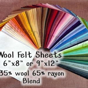 May include: A fan of colorful wool felt sheets in various shades, including white, orange, yellow, red, pink, purple, blue, green, and gray. The text indicates the sheets are 6"x8" or 9"x12" and are a 35% wool and 65% rayon blend.