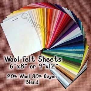 May include: A fan of colorful wool felt sheets in various colors, including white, yellow, orange, red, and blue. The sheets are available in 6"x8" or 9"x12" sizes and are a blend of 20% wool and 80% rayon. The text "Wool Felt Sheets" is visible.