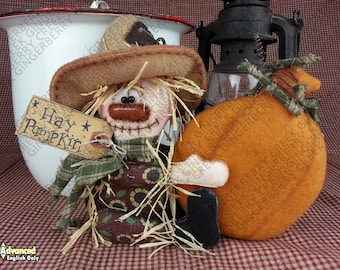 May include: A handcrafted scarecrow doll with a felt hat and a tag that says "Hay Pumpkin." Beside it is an orange felt pumpkin and a vintage lantern. The items are set against a red and white checkered background.