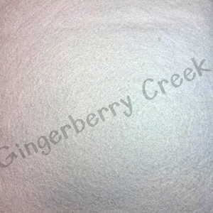 May include: A close-up view of a light gray, textured fabric. The fabric has a soft, slightly fuzzy appearance. The words "Gingerberry Creek" are printed diagonally across the fabric in a light gray color.