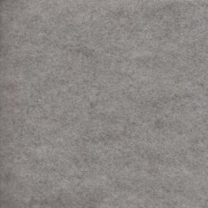 Puede incluir: Primer plano de una tela de fieltro gris. La tela tiene un aspecto suave y texturizado con una superficie ligeramente moteada. El color es un gris medio, sin patrones ni diseños visibles. El material parece ser una lámina sólida y uniforme.