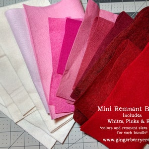 May include: A collection of felt fabric remnants in shades of white, pink, and red. The bundle includes various sizes and colors, as indicated by the text "Mini Remnant Bundle includes Whites, Pinks & Reds". The felt is arranged in a fan shape.