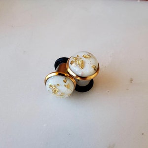 White resin with gold and opalescent flakes in a gold bezeled setting plugs gauges 8g 6g 4g 2g 0g 00g 7/16” 1/2” 3mm-12mm