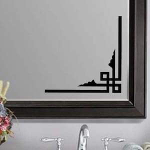 May include: Black and white geometric corner design wall decal. The decal is applied to a mirror with a black frame.