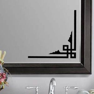 May include: Black and white geometric corner design wall decal. The decal is applied to a mirror with a black frame.