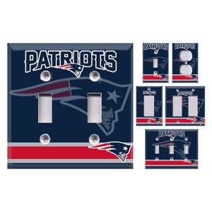 May include: A collection of New England Patriots-themed light switch covers. The covers feature the team's logo and name in white, red, and blue. The main cover has two toggle switches. Additional covers include single toggle, double toggle, and outlet configurations.