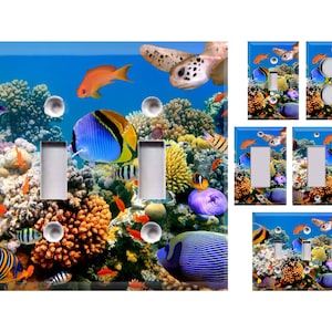 May include: A set of light switch and outlet covers featuring a colorful underwater scene with coral reefs, tropical fish, and a sea turtle. The design includes various shades of blue, green, orange, yellow, and purple.