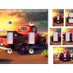 May include: A red vintage pickup truck with a wooden bed is driving through a desert landscape at sunset. The truck has a weathered look and is surrounded by sand and cacti. The sky is a vibrant orange and pink.