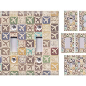 May include: Set of six light switch covers featuring a vintage airplane pattern in shades of blue, green, brown, yellow, and red on a beige background.